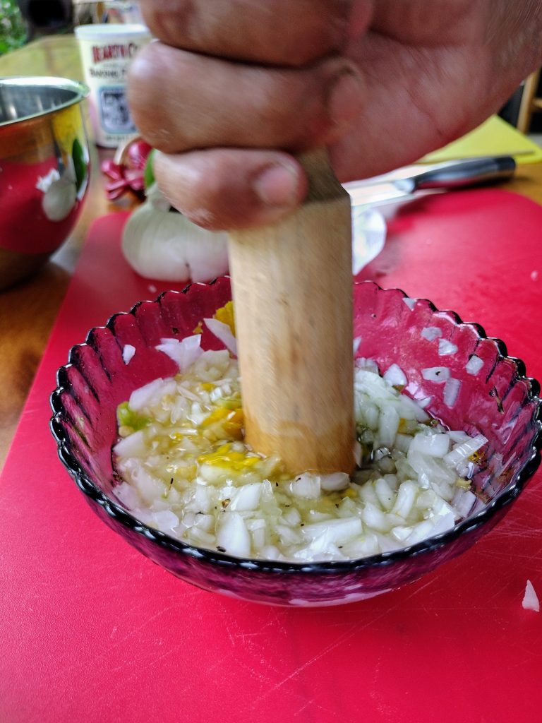 hand mashing ingredients for onion sauce